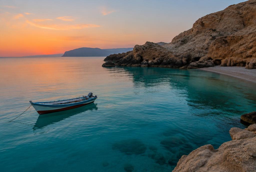Turquoise Omani coastline with white sand beach framed by rocky cliffs